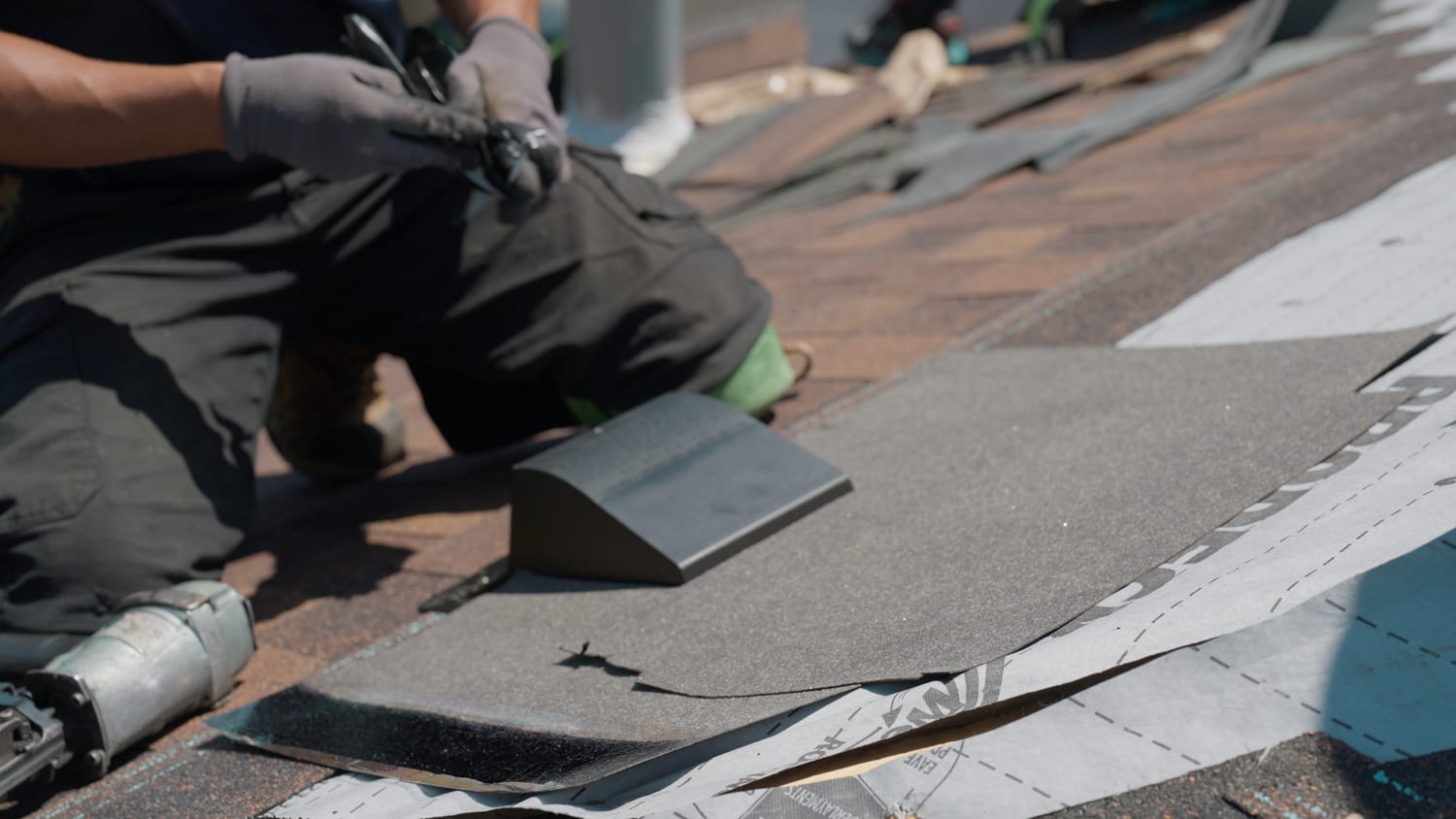 Eave protection membrane and synthetic underlayment installed beneath new shingles on a Kitchener-Waterloo roof, with a box vent being fitted