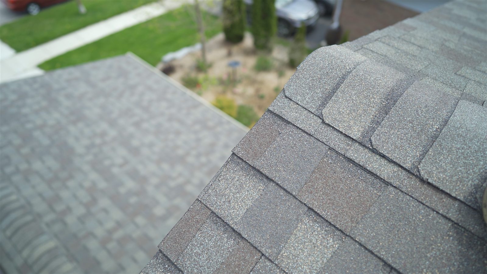 Close view of a finished hip and ridge on a new architectural shingle roof, showing the granule blend and evenly spaced cap shingles